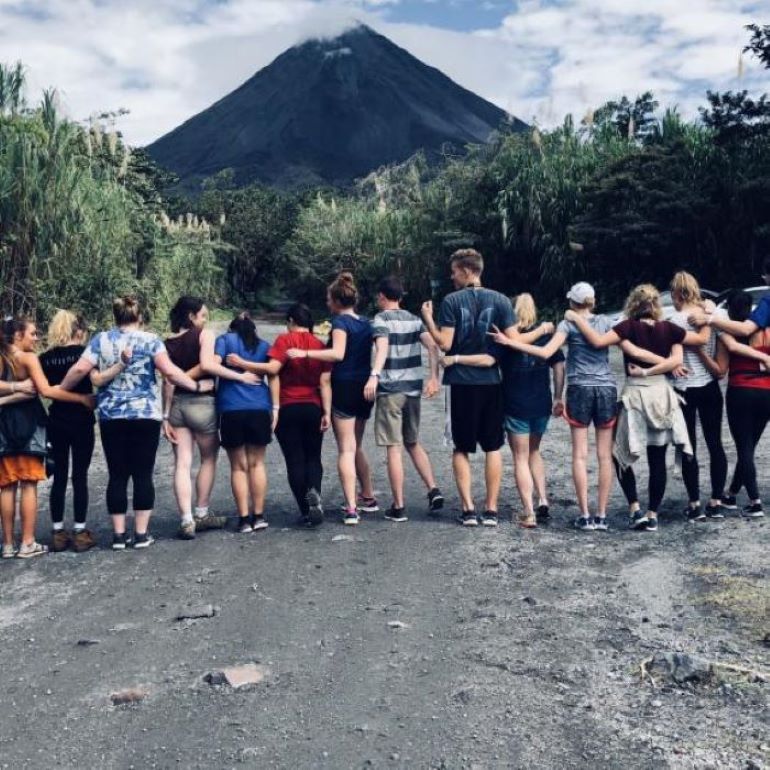 Students with arms linked in front of mountain