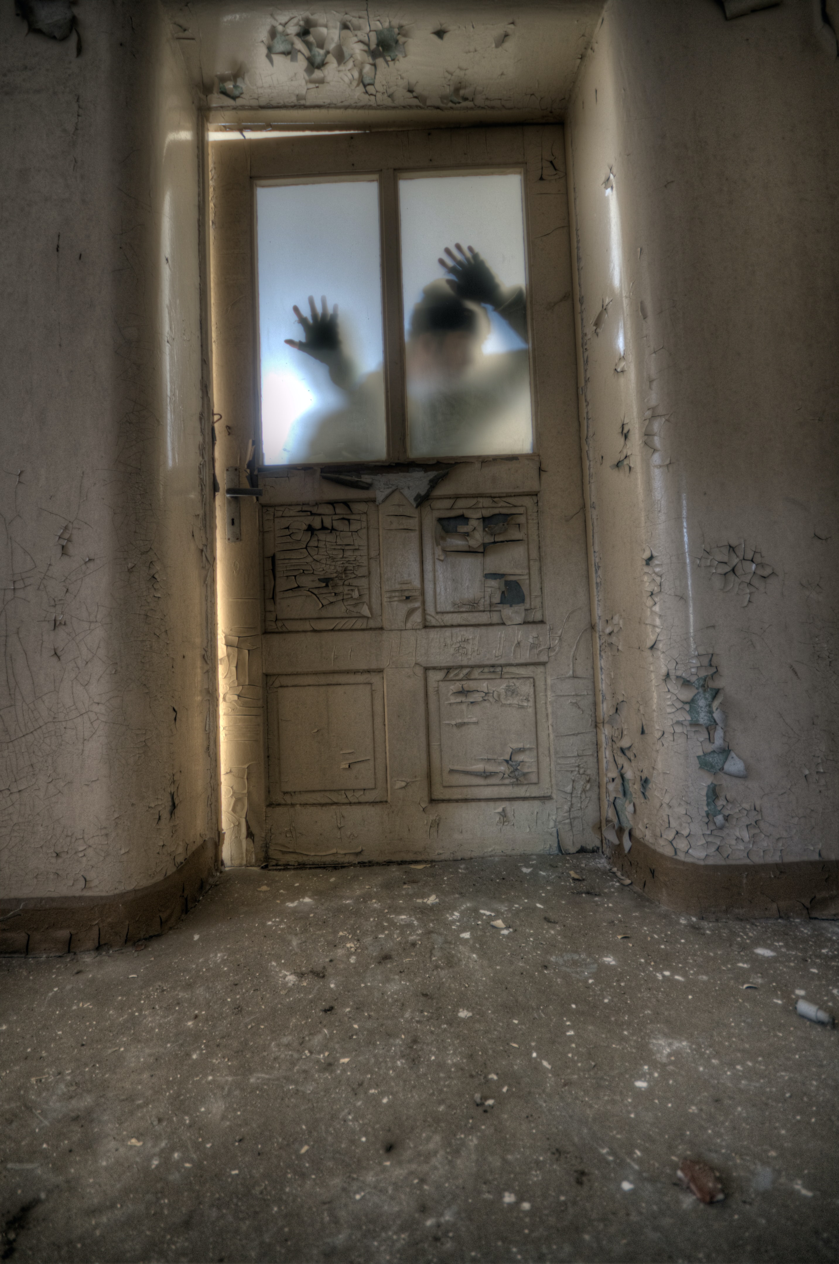 Shadowy figures seen through decrepit hallway door