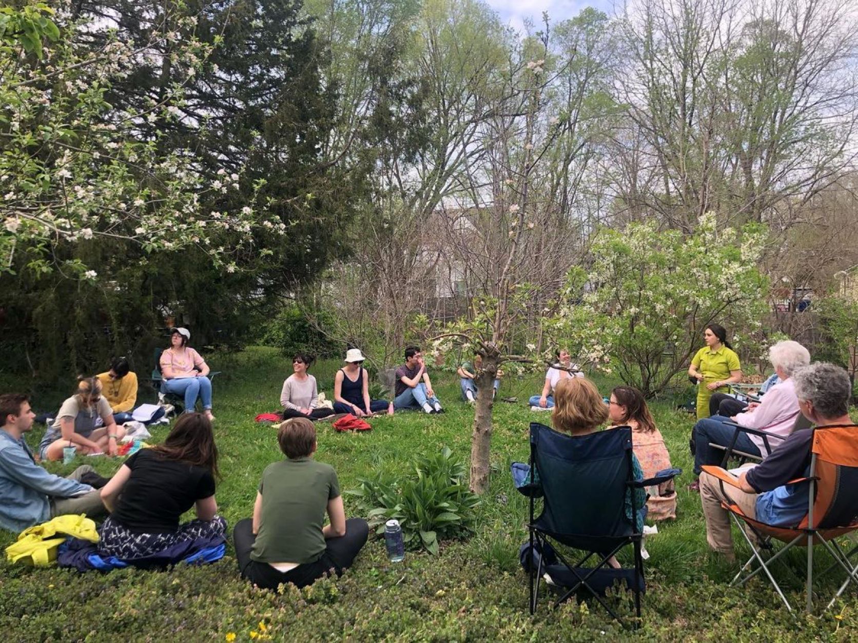 Photo of people sitting in circle in grass outside